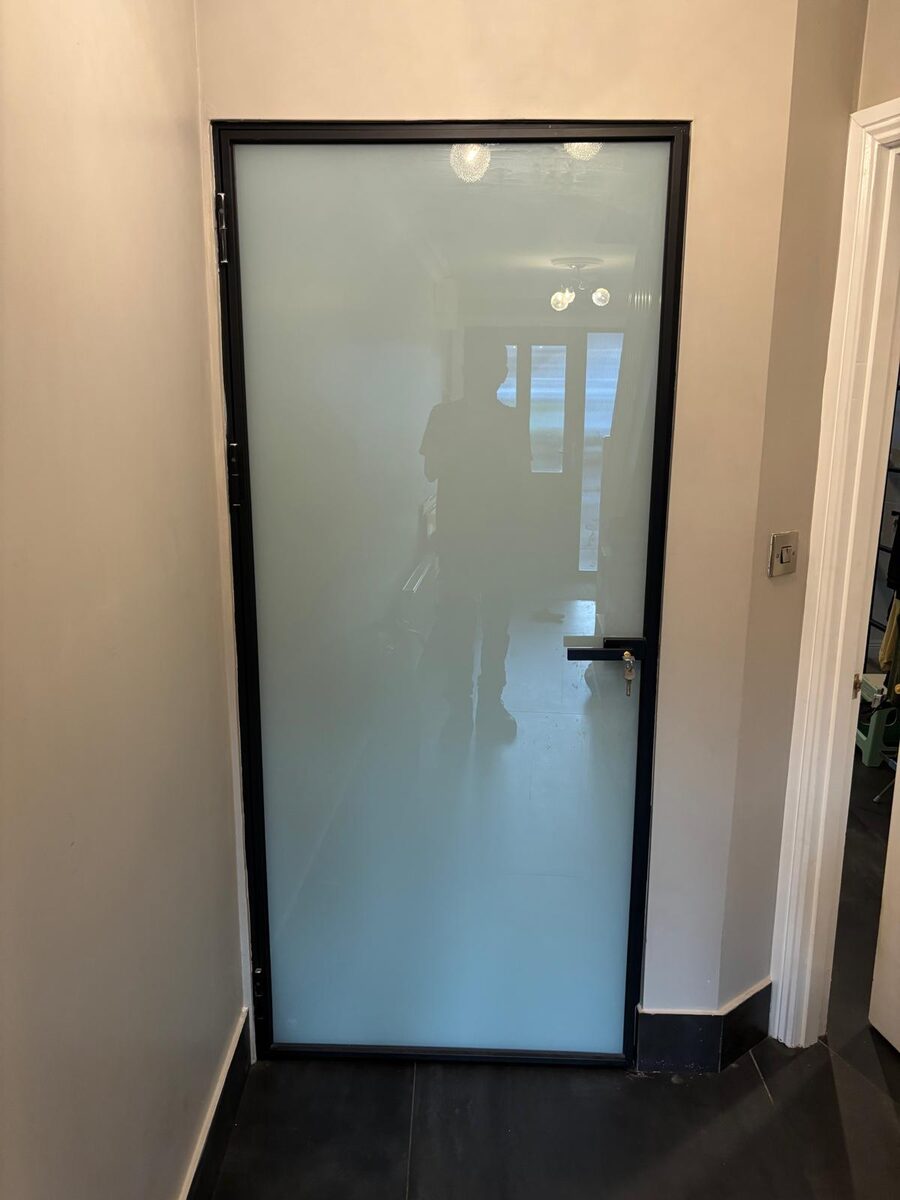A black framed frosted glazed door fitted in a Dublin hallway