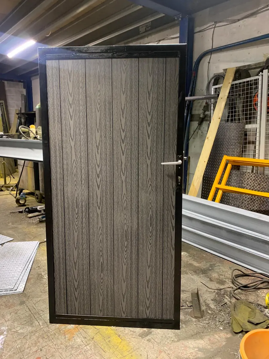 A steel framed side gate with grey woodgrain composite boards, finished in the gate maker's workshop before fitting