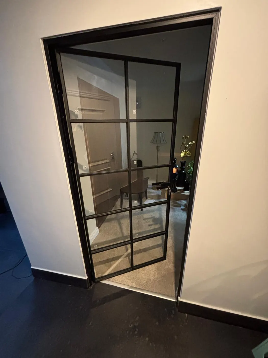 Black-framed glazed internal door standing open into a living room in a Dublin home