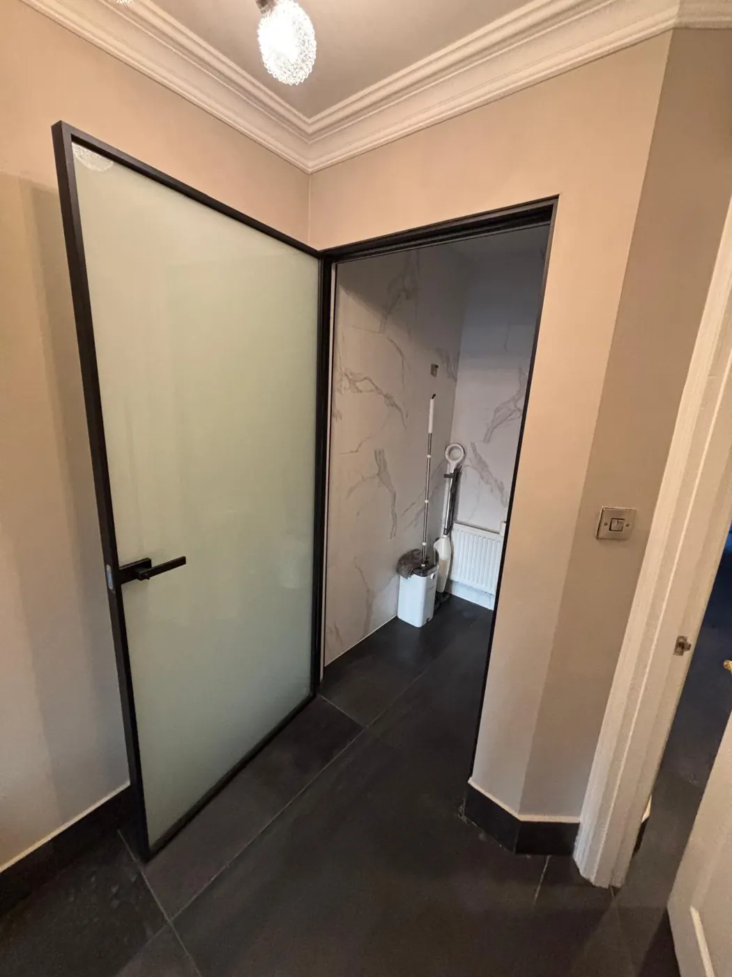 Black-framed frosted glazed internal door supplied and fitted in a Dublin hallway with marble-effect tiling