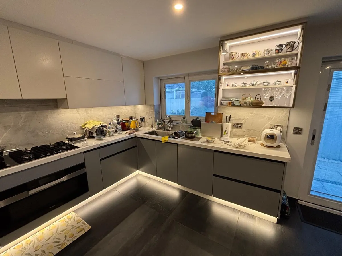 The hob run and window in a grey and white handleless kitchen