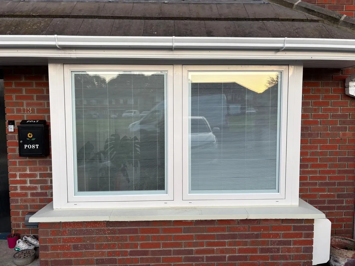 A new white window fitted in a red brick Dublin home