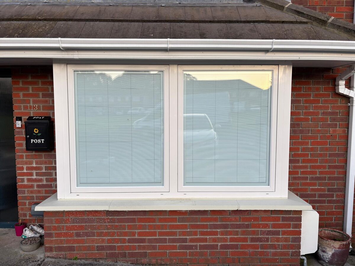 A new white window fitted in a red brick Dublin home, daylight