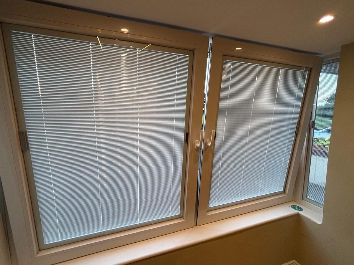 A corner window seen from inside a Dublin home, with blinds fitted