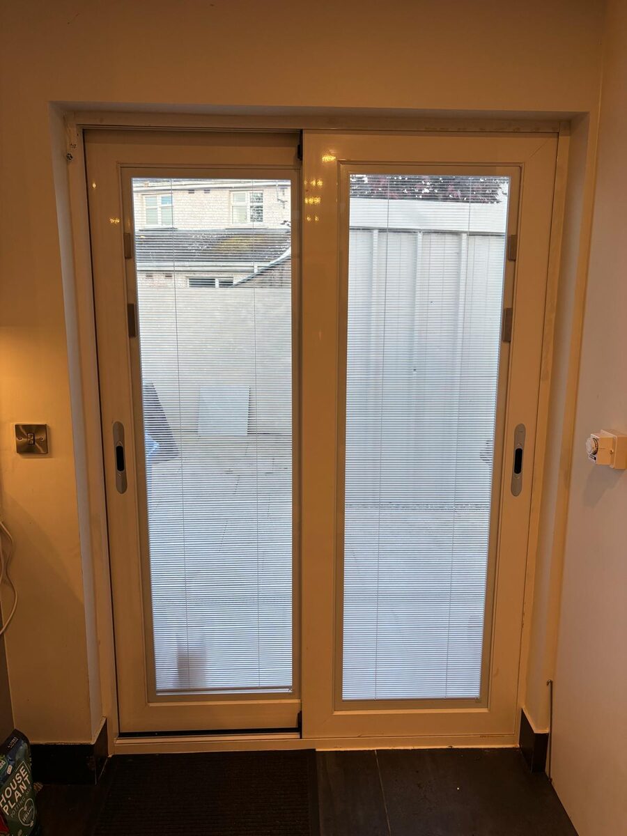 A patio door and window seen from inside a Dublin home, with blinds fitted